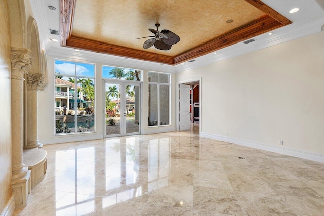 empty room featuring a raised ceiling, ceiling fan, and french doors