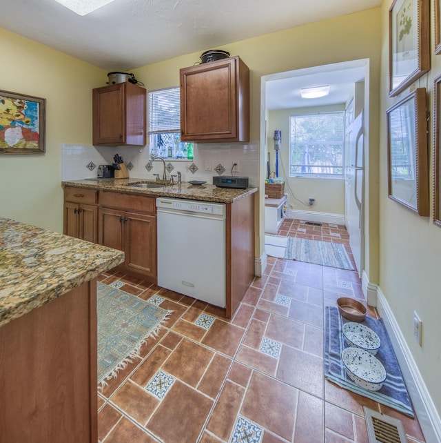 kitchen with decorative backsplash, white appliances, a healthy amount of sunlight, and sink