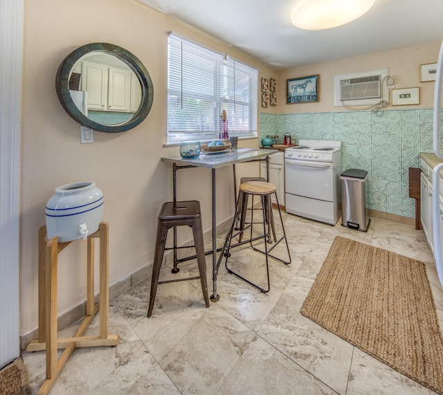 kitchen with white range oven, a wall unit AC, and a kitchen bar