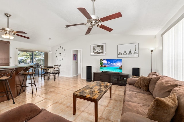 living room with ceiling fan, lofted ceiling, and light tile patterned flooring