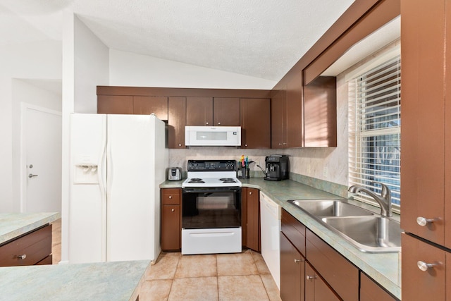 kitchen featuring white appliances, sink, vaulted ceiling, a textured ceiling, and light tile patterned flooring