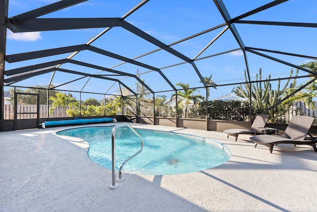 view of pool with glass enclosure and a patio