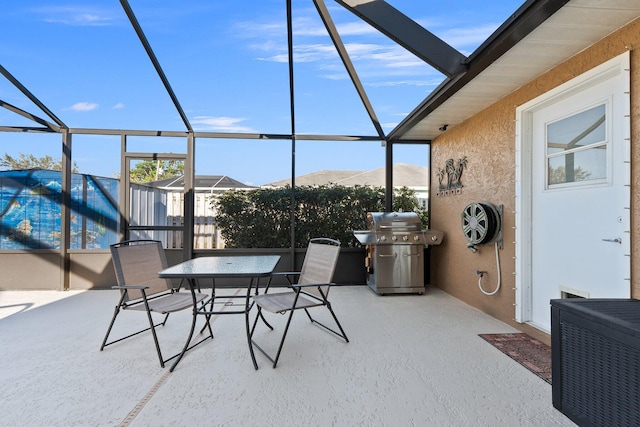 view of patio / terrace with a mountain view, glass enclosure, and grilling area