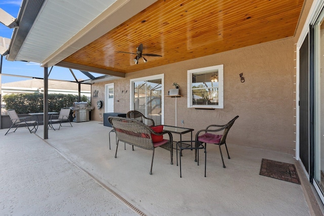 view of patio with ceiling fan, a grill, and a lanai