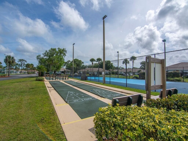 view of home's community with a yard and tennis court