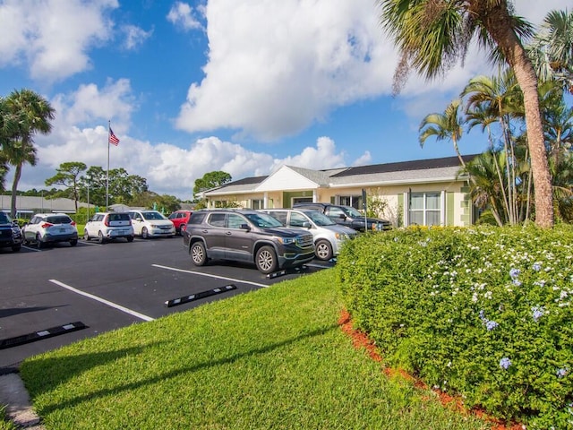 view of parking with a lawn