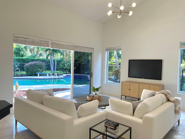 1627 Mayacoo Lakes Blvd, West Palm Beach, FL 33411 - living room with light tile patterned flooring, a towering ceiling, a chandelier, and baseboards
