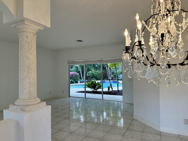 interior space featuring light tile patterned floors, decorative columns, and an inviting chandelier