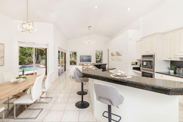 1627 Mayacoo Lakes Blvd, West Palm Beach, FL 33411 - kitchen with a chandelier, stainless steel double oven, light tile patterned floors, a breakfast bar, and open floor plan