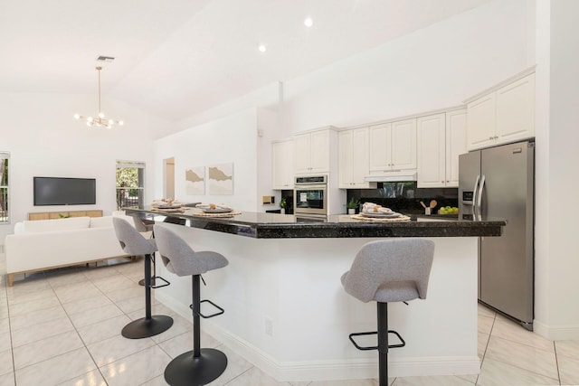 1627 Mayacoo Lakes Blvd, West Palm Beach, FL 33411 - kitchen with appliances with stainless steel finishes, under cabinet range hood, high vaulted ceiling, a breakfast bar area, and light tile patterned flooring