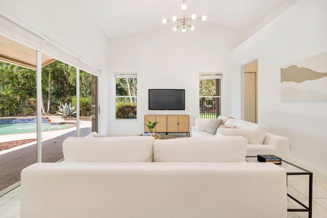 1627 Mayacoo Lakes Blvd, West Palm Beach, FL 33411 - living area with a chandelier, light tile patterned floors, high vaulted ceiling, and baseboards