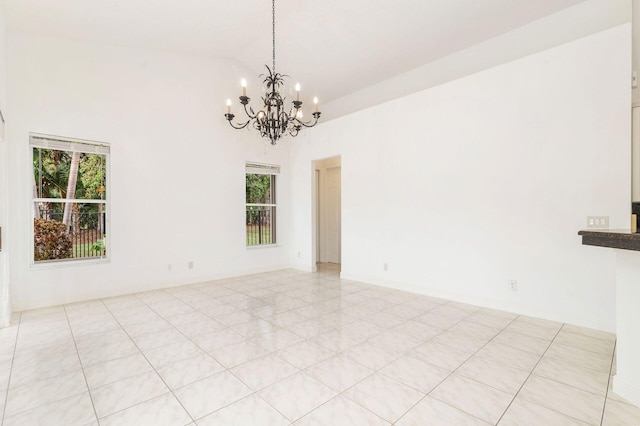 spare room featuring a chandelier, a wealth of natural light, and light tile patterned flooring