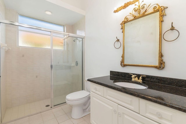 bathroom with tile patterned floors, a shower with door, vanity, and toilet