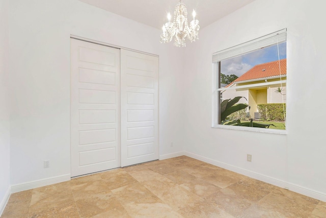 unfurnished bedroom with a closet and an inviting chandelier