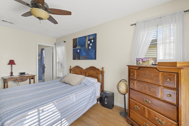 bedroom with ceiling fan, a textured ceiling, and light wood-type flooring