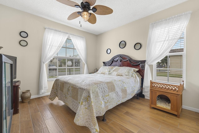 bedroom featuring hardwood / wood-style floors, a textured ceiling, and ceiling fan