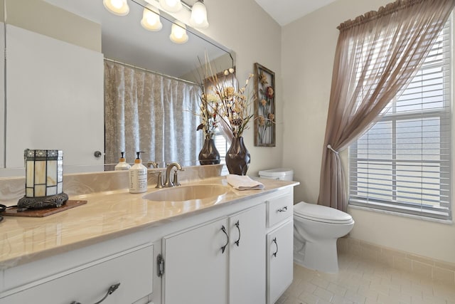 bathroom featuring tile patterned floors, plenty of natural light, vanity, and toilet