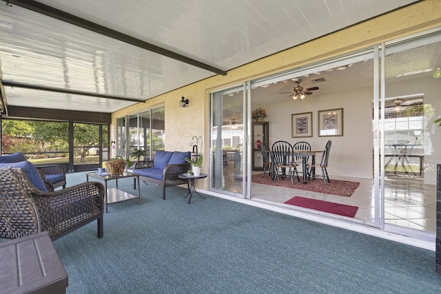 sunroom featuring ceiling fan, plenty of natural light, and beamed ceiling