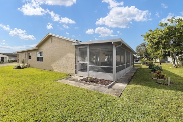 back of house featuring a sunroom and a yard