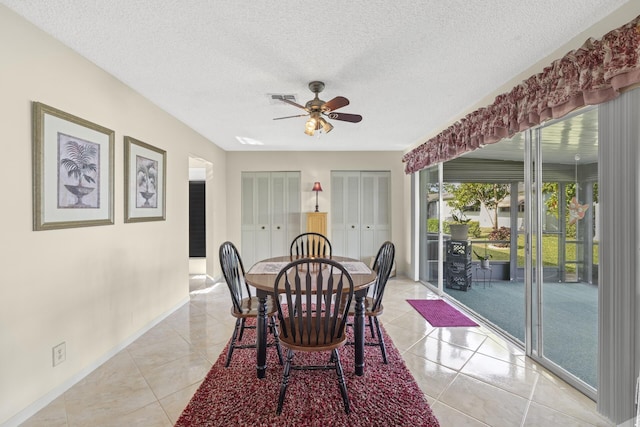 tiled dining space featuring ceiling fan and a textured ceiling