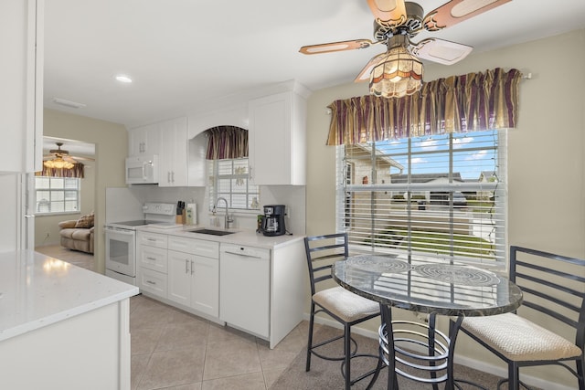 kitchen featuring white cabinets, plenty of natural light, white appliances, and sink