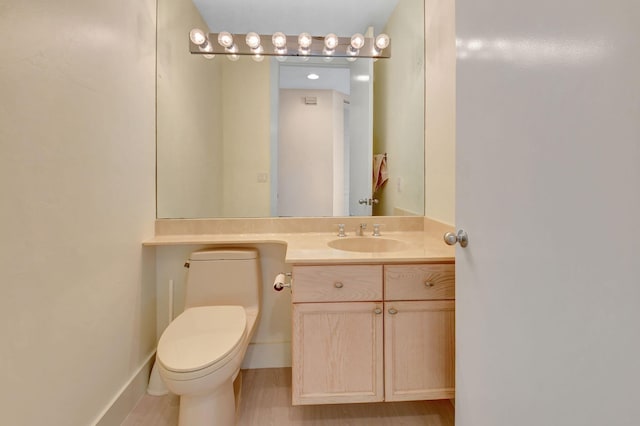 bathroom featuring hardwood / wood-style floors, vanity, and toilet