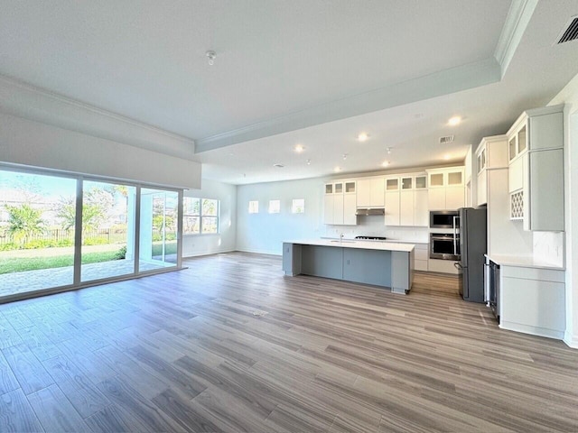 kitchen featuring a center island, white cabinets, stainless steel appliances, and light hardwood / wood-style flooring