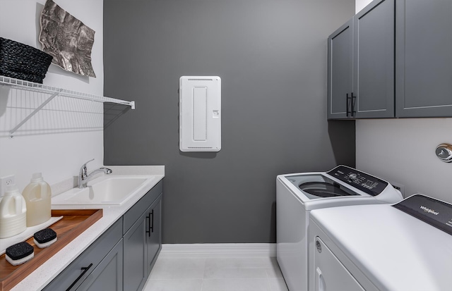 laundry room with washer and dryer, cabinets, light tile patterned floors, and sink