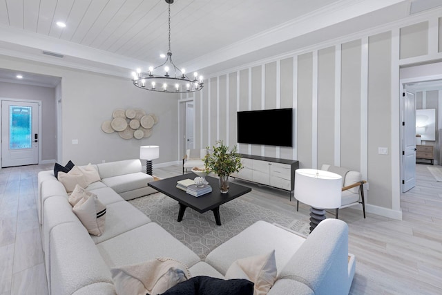 living room featuring crown molding, light hardwood / wood-style flooring, and an inviting chandelier