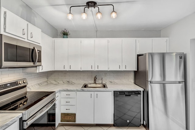 1707 17th Ln, Palm Beach Gardens, FL 33418 - kitchen featuring stainless steel appliances, a sink, decorative backsplash, white cabinetry, and light tile patterned floors