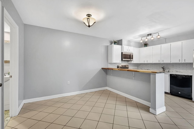 kitchen with backsplash, white cabinets, a kitchen breakfast bar, kitchen peninsula, and stainless steel appliances