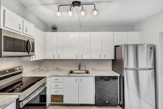 kitchen featuring decorative backsplash, white cabinetry, sink, and appliances with stainless steel finishes