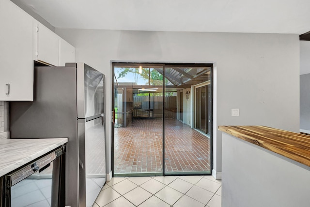 kitchen featuring dishwasher, stainless steel fridge, and white cabinetry