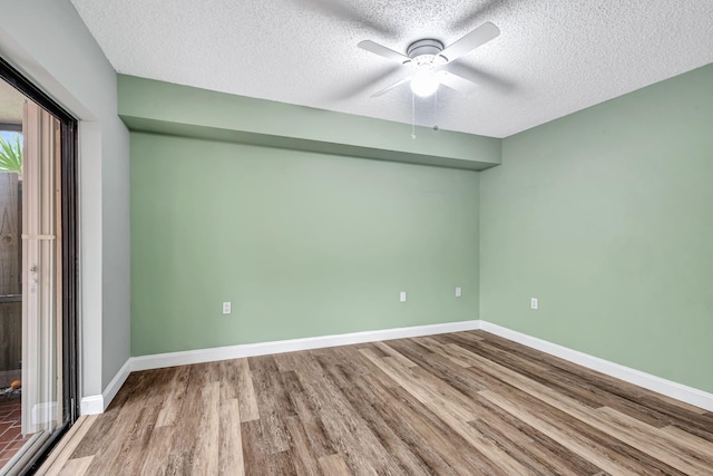 empty room with hardwood / wood-style floors, a textured ceiling, and ceiling fan