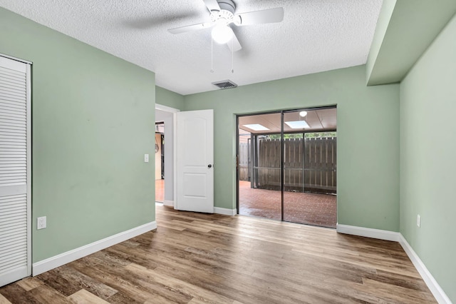 spare room with ceiling fan, hardwood / wood-style floors, and a textured ceiling