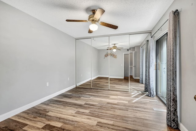 unfurnished room with ceiling fan, light hardwood / wood-style floors, and a textured ceiling