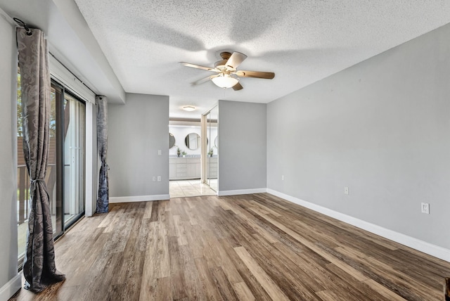 unfurnished living room with a healthy amount of sunlight, ceiling fan, light hardwood / wood-style floors, and a textured ceiling