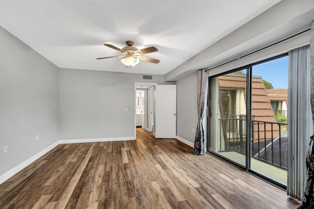 empty room with ceiling fan, a textured ceiling, and light wood-type flooring