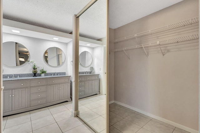 bathroom featuring a textured ceiling, vanity, and tile patterned floors