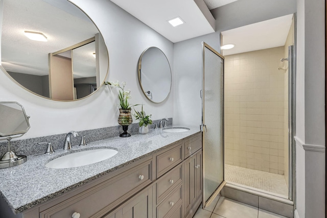 bathroom featuring tile patterned flooring, vanity, and tiled shower