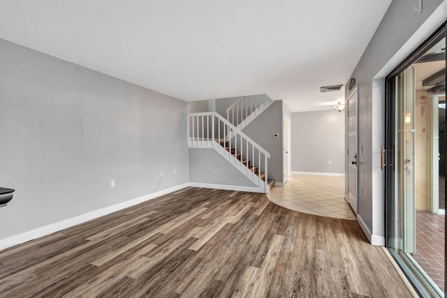 1707 17th Ln, Palm Beach Gardens, FL 33418 - unfurnished living room featuring wood finished floors, stairs, and baseboards