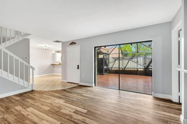 1707 17th Ln, Palm Beach Gardens, FL 33418 - empty room featuring wood finished floors, baseboards, stairs, and a sunroom