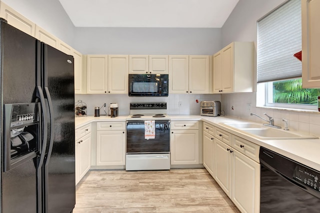 kitchen with black appliances, decorative backsplash, light hardwood / wood-style floors, and sink