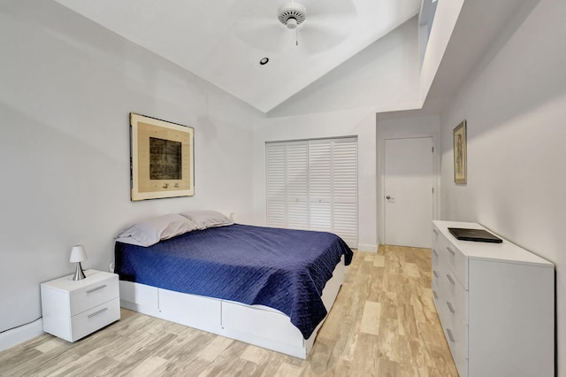 bedroom featuring ceiling fan, a closet, lofted ceiling, and light wood-type flooring