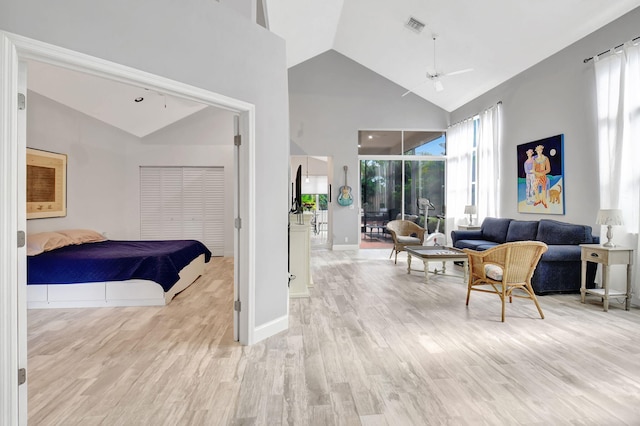 bedroom with light hardwood / wood-style floors and high vaulted ceiling