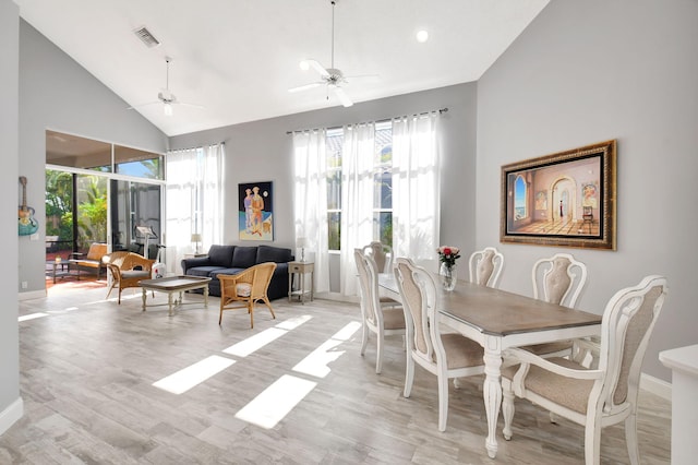 dining space featuring ceiling fan, light hardwood / wood-style flooring, and high vaulted ceiling