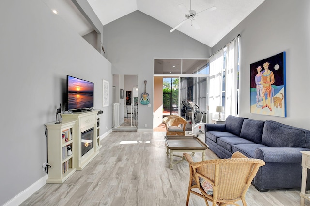 living room with ceiling fan, light hardwood / wood-style floors, and high vaulted ceiling