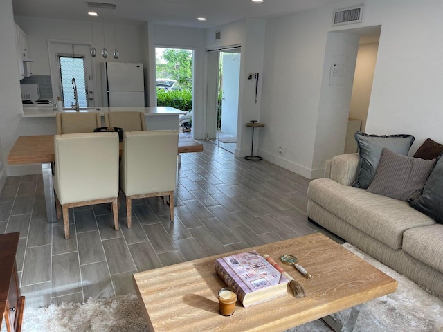 living room with hardwood / wood-style floors and sink