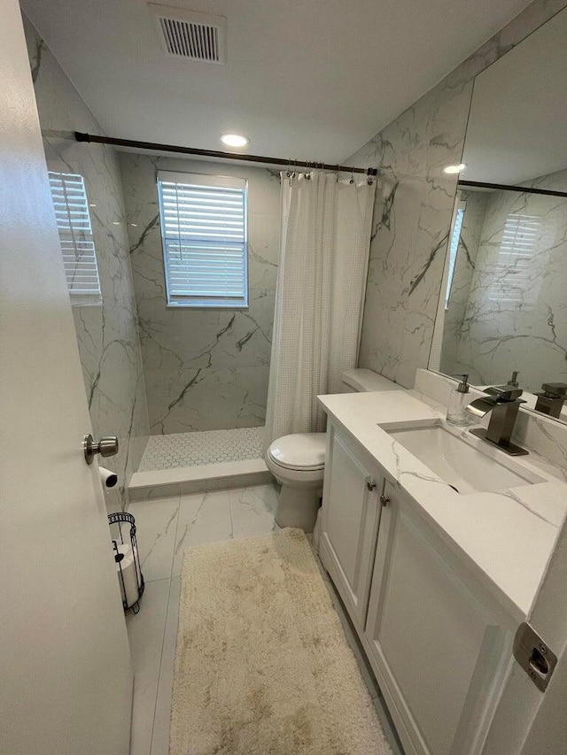 bathroom with vanity, toilet, walk in shower, and tile walls