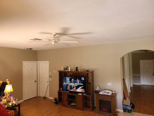 living room with wood-type flooring and ceiling fan